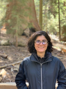Caroline Muglia smiling in a forest background